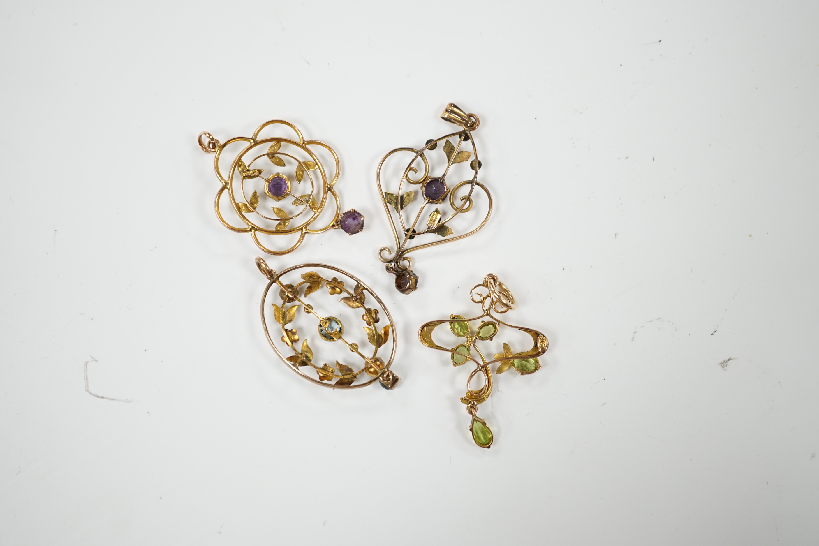 Three assorted early 20th century 9ct and gem set pendants, one other similar yellow metal and gem set pendant, largest, 40mm, gross weight 7.5 grams.